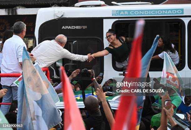 Brazil's former president and presidential candidate for the leftist Workers Party , Luiz Inacio Lula da Silva, greets supporters on a bus during a...