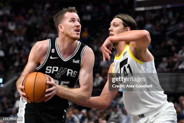 Jakob Poeltl of the San Antonio Spurs drives into Kelly Olynyk of the Utah Jazz during a game at Vivint Arena on October 11, 2022 in Salt Lake City,...