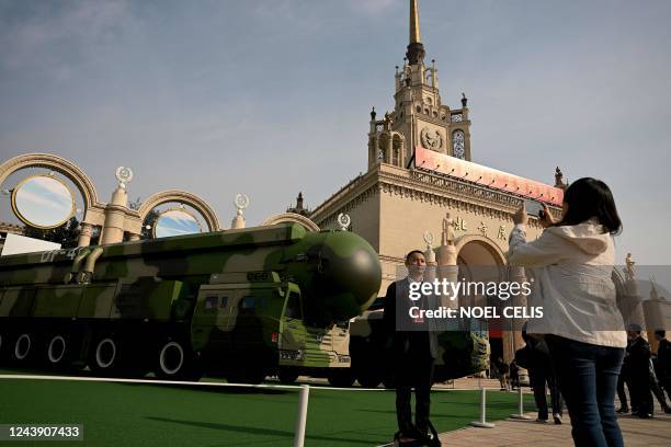 Man poses in front of a Dongfeng-41 intercontinental ballistic missile and its mobile launcher on display at the Beijing Exhibition Center, where an...