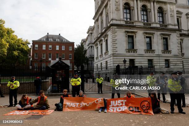 Activists from the 'Just Stop Oil' coalition group stage a sit down at the back entrance to Downing Street in London on October 12, 2022. - Just Stop...