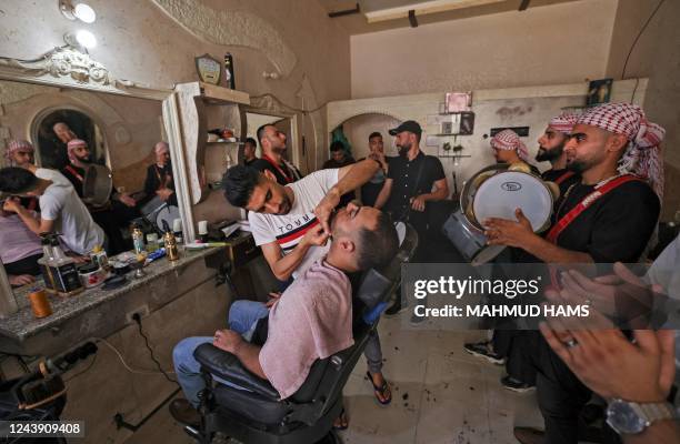 Groom is groomed by a barber as he prepares for his wedding in the Palestinian city of Beit Lahia in the northern Gaza Strip on October 11, 2022.