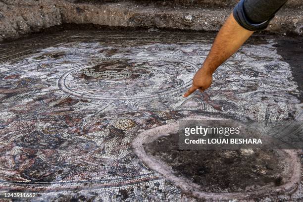 This picture taken on October 12, 2022 shows a view of a mosaic floor dating to the Roman era being excavated in the city of al-Rastan in Syria's...