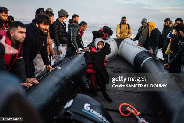 Migrants move a smuggling boat into the water as they prepare to embark on the beach of Gravelines, near Dunkirk, northern France on October 12 in a...