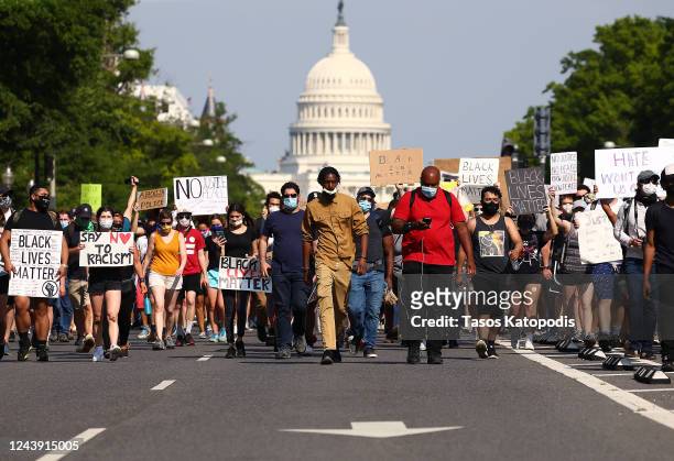 Demonstrators march down Pennsylvania Avenue near the Trump International Hotel during a protest against police brutality and the death of George...