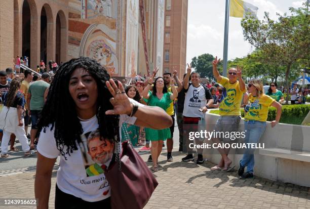 Supporters of Brazilian President and re-election candidate Jair Bolsonaro flash the Victory sign as a supporter of Brazil's former president and...
