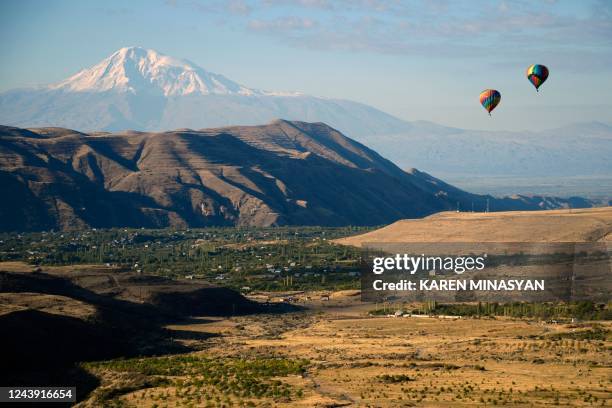 Ballooning enthusiasts fly their hot-air balloons in the sky near the settlement of Garni in the Kotayk region of Armenia during the "Discover...