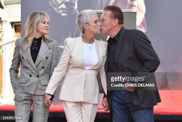 Actress Melanie Griffith looks on as US actress Jamie Lee Curtis give a kiss to Austrian-US actor and former Governor of California Arnold...