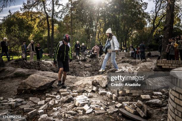 Ukrainian adults and children visit the crater, occurred after the Russian missile strikes, at the Taras Shevchenko Park in Kyiv, Ukraine on October...