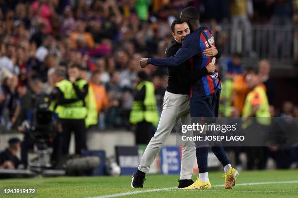 Barcelona's French forward Ousmane Dembele celebrates scoring the opening goal with Barcelona's Spanish coach Xavi during the UEFA Champions League...