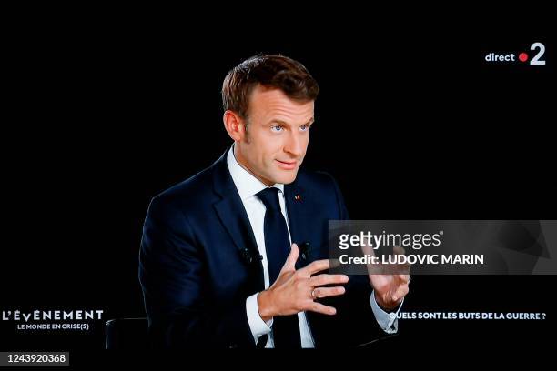 In this screen shot made on Ocober 12, 2022 French president Emmanuel Macron gestures as he speaks during an interview as part of a new show entitled...