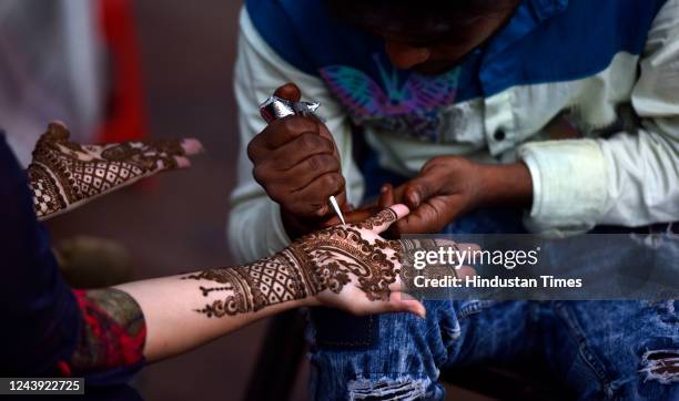 Women with mehendi decorated hands on the eve of Karva Chauth near Hanuman Mandir, at Connaught Place on October 12, 2022 in New Delhi, India. The...