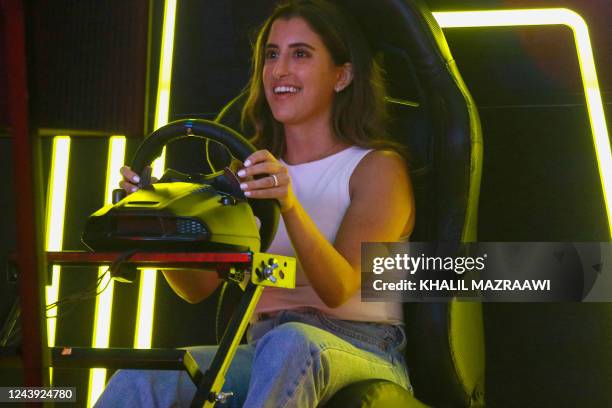 An attendee sits behind the wheel during the finals of the Toyota Gazoo Middle East and North Africa eSports Cup in the Jordanian capital Amman on...