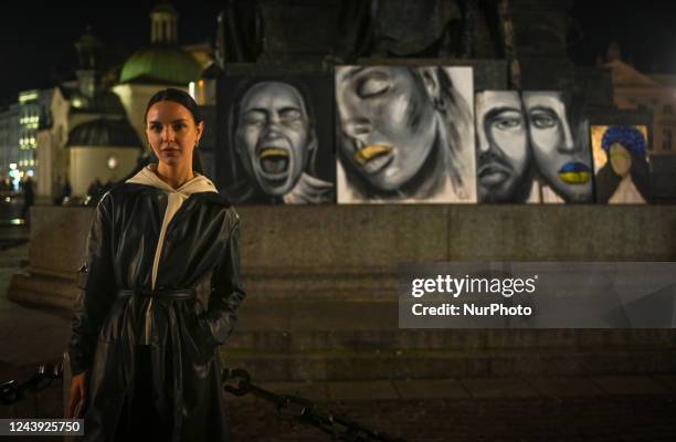 Ukrainian artist Julia ANGELIUK poses for a pictures next to her paintings during the daily protest to Support Ukraine next to the Adam Mickiewicz...
