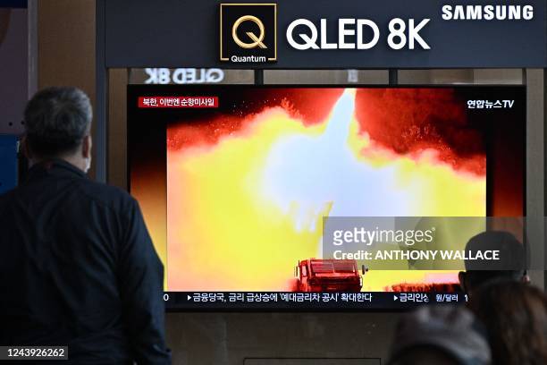 Man watches a news broadcast showing a photo of a North Korean missile test, at a railway station in Seoul on October 13, 2022. - Kim Jong Un...