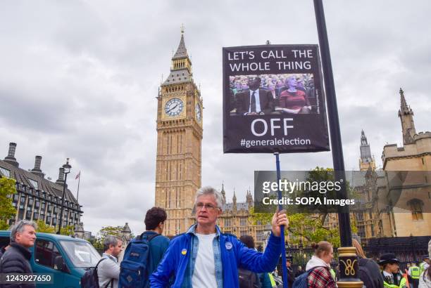 Protester holds a placard calling for a general election during the demonstration in Parliament Square. Anti-Tory protesters gathered in Westminster...