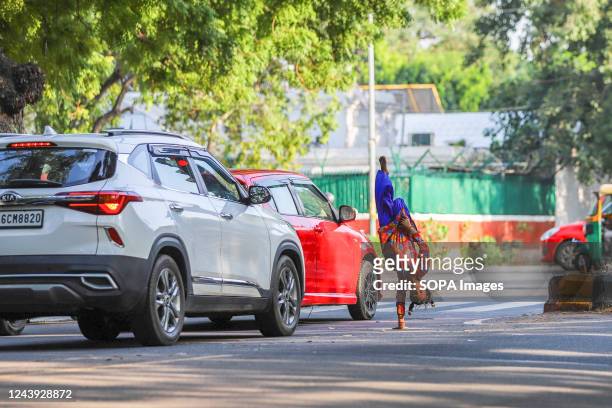 Poor girl child performs acrobatics in front of vehicles at a traffic signal. Poor and underprivileged children often perform acrobatics or juggling...