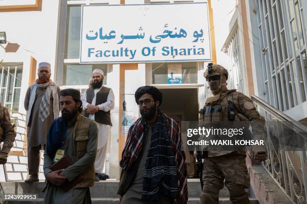 Taliban security personnel escort Taliban members as they leave the Faculty of Sharia as studenta sit for their university entrance exams at Kabul...