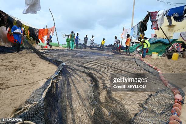 Children of Senegalese fishermen arrange fishing nets on the coast of Saint Louis, near a platform where an important offshore gas discovery is being...