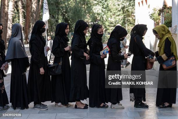 An Afghan female guard frisks students before they sit for entrance exams at the Kabul University in Kabul on October 13, 2022.