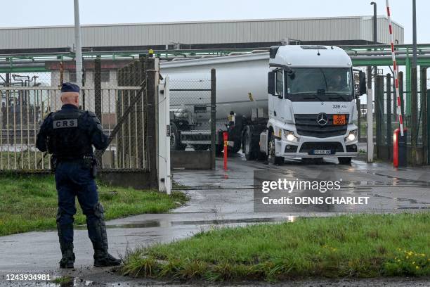 Tanker truck exits the TotalEnergies fuel depot of Mardyck, near Dunkirk, northern France, on October 13 as a CRS riot police stands outside, after...