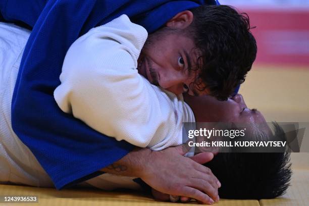 Germany's Johannes Frey and China's Ruixuan Li compete in the bronze medal contest of the mixed teams event at the 2022 World Judo Championships at...