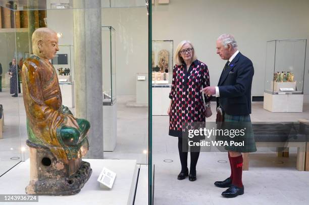 King Charles III alongside senior museum manager Jane Rowlands as they view the figure of a Luohan during a visit to the Burrell Collection to...