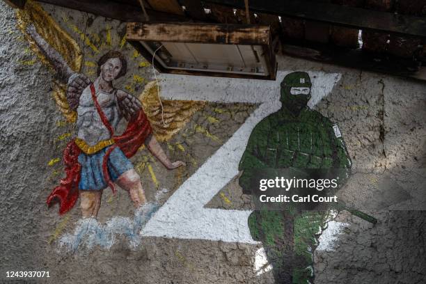 Picture of a Russian soldier next to the 'Z' military symbol and St. Michael the Archangel is seen on a wall in a compound used by the Russian...