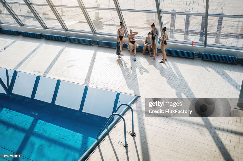 Weibliche synchrone Schwimmteam entspannen am Pool