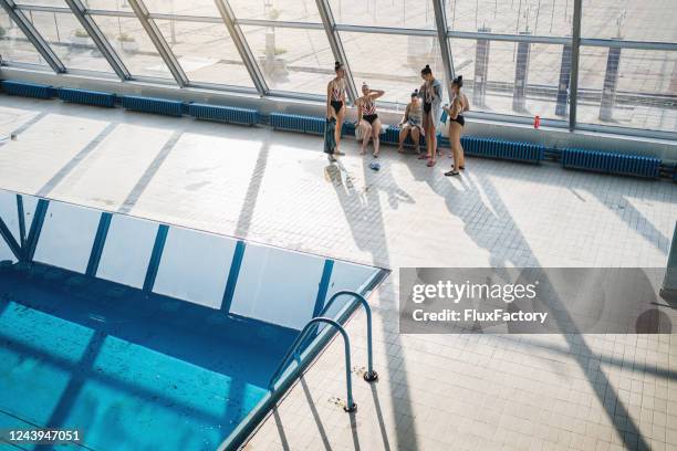 weibliche synchrone schwimmteam entspannen am pool - hallenbad stock-fotos und bilder