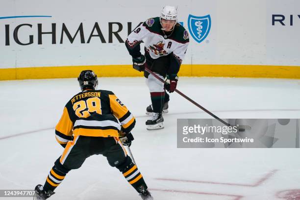 Arizona Coyotes Left Wing Clayton Keller moves the puck as Pittsburgh Penguins Defenseman Marcus Pettersson defends during the first period in the...