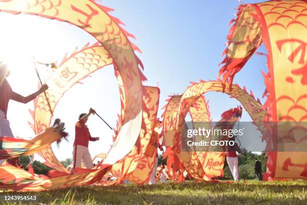 Dragon dance lovers wave streamers as they greet the opening of the 20th National Congress of the Communist Party of China in Hefei, Anhui province,...