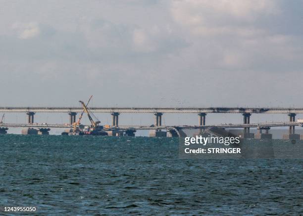 This picture taken on October 14, 2022 shows damaged parts of the Kerch Bridge that links Crimea to Russia, which was hit by a blast on October 8,...