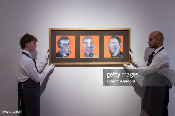 Art handlers hold a painting titled 'Three Studies for Self-Portrait' by Francis Bacon during a photo call to present the highlights from the estate...