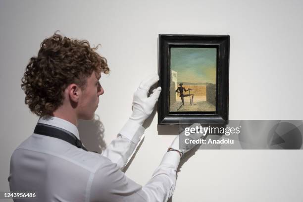 An art handler holds a painting titled 'Le spectre de Vermeer de Delft' by Salvador Dali during a photo call to present the highlights from the...