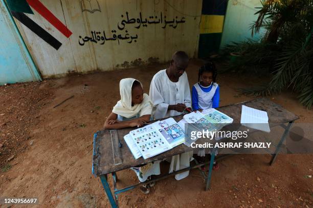 Teacher sits with students at a school for girls in Burri, in the eastern part of the Sudanese capital Khartoum, on September 14, 2022. - Sudan's...