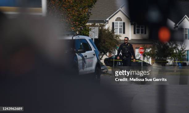 Police officer walks along Castle Pines Drive in the Hedingham neighborhood on October 14, 2022 in Raleigh, North Carolina. Police are investigating...