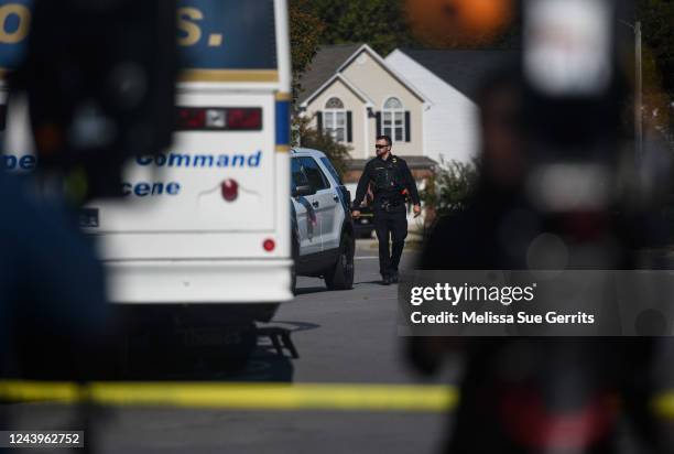 Police officer walks along Castle Pines Drive in the Hedingham neighborhood on October 14, 2022 in Raleigh, North Carolina. Police are investigating...