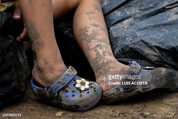 The feet covered with mud of a Venezuelan migrant child are seen at Canaan Membrillo village, the first border control of the Darien Province in...