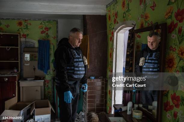 Police forensics investigator checks a building used as a residence by the head of Russian occupying forces as he searches for evidence of war...