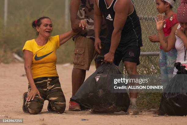 Magdalena Avila of Cuba becomes emotional while waiting to be processed by US Border Patrol after illegally crossing the US southern border with...