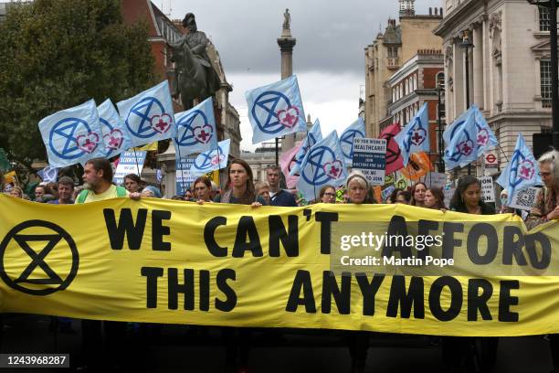 Demonstrators march to Downing Street behind a banner saying 'We Can't Afford This Anymore' on October 14, 2022 in London, England. Extinction...