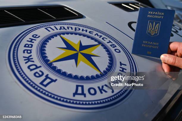 Ukrainian citizen holds a passport next to the mobile passport office in Krakow. Mobile passport points for Ukrainian citizens in Poland have been...