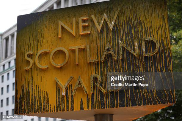 An activist from Just Stop Oil uses a pressurised fire extinguisher to spray paint all over the iconic New Scotland Yard sign on October 14, 2022 in...