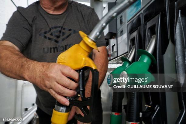 Motorist takes fuel at a gas station in Blois on October 14 as filling stations across France are low on petrol as a pay-related strike by workers at...