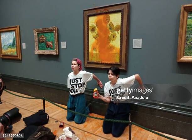 Climate protesters hold a demonstration as they throw cans of tomato soup at Vincent van Goghâs âSunflowersâ at the National Gallery in London,...