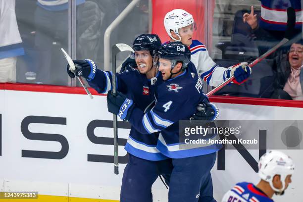 Mark Scheifele and Neal Pionk of the Winnipeg Jets celebrate a first period goal against the New York Rangers at the Canada Life Centre on October...