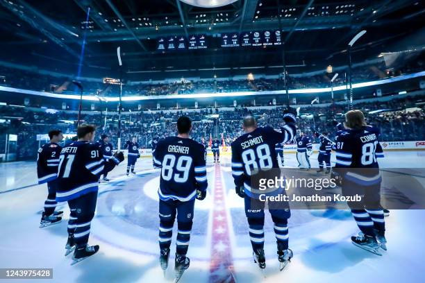 Members of the Winnipeg Jets salute the fans following the player introductions prior to their home opener against the New York Rangers at the Canada...