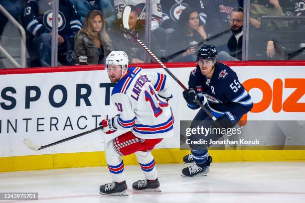 Alexis Lafreniere of the New York Rangers and Mark Scheifele of the Winnipeg Jets keep an eye on the play during first period action at the Canada...