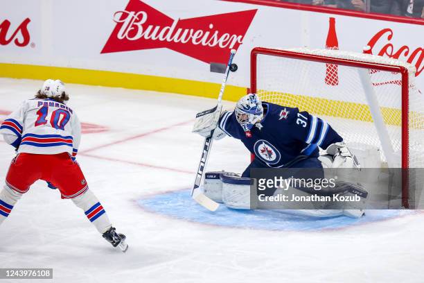 Goaltender Connor Hellebuyck of the Winnipeg Jets makes a stick save on Artemi Panarin of the New York Rangers during a first period breakaway chance...