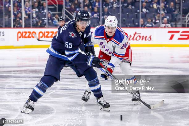 Mark Scheifele of the Winnipeg Jets and Kaapo Kakko of the New York Rangers chases the loose puck during second period action at the Canada Life...